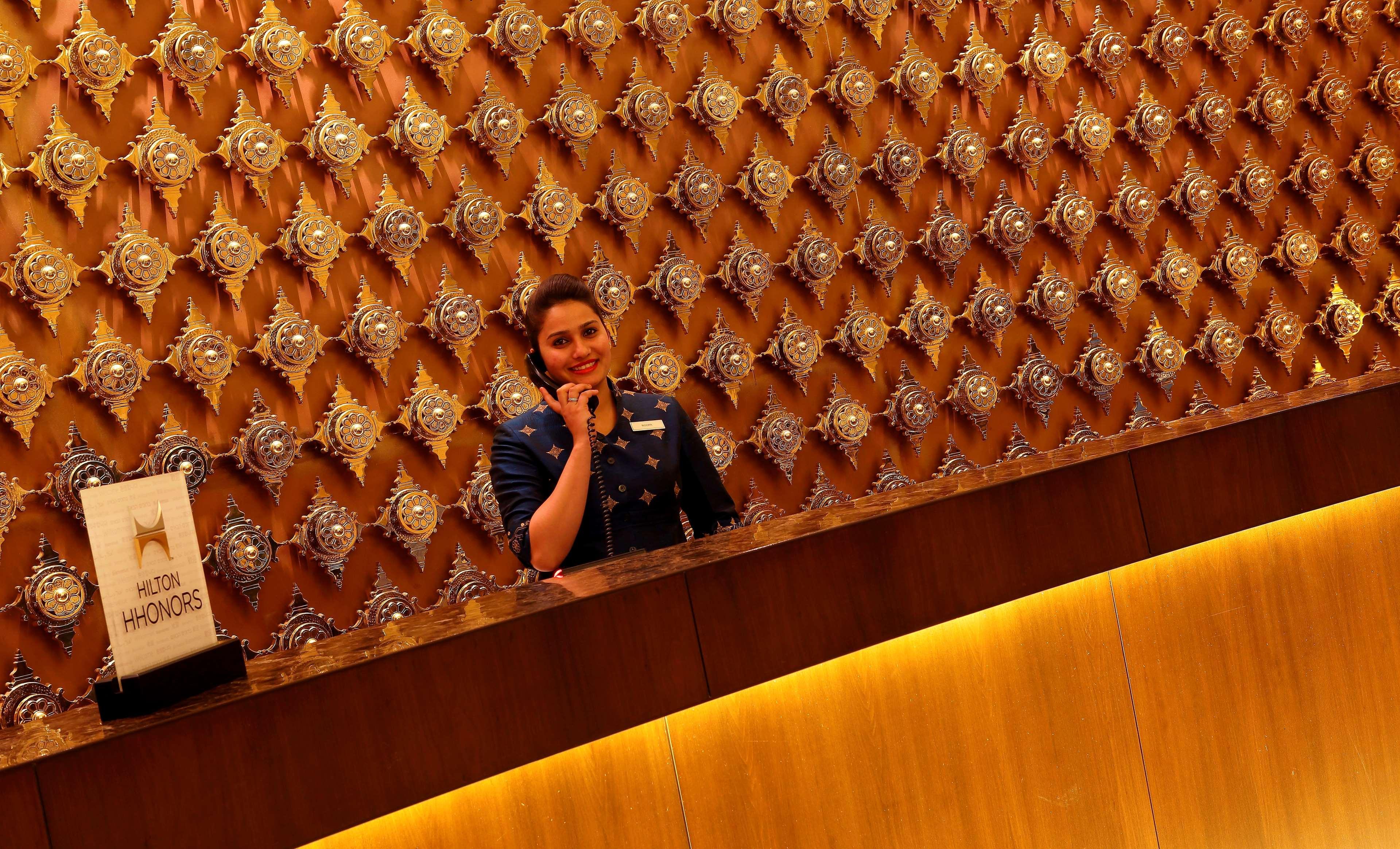 힐튼 자이푸르 호텔 외부 사진 A hotel receptionist at work